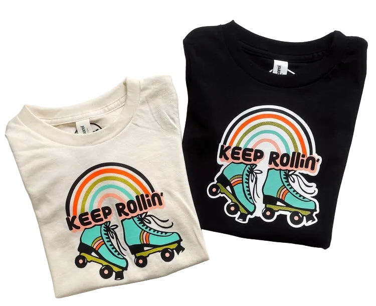 Two folded t-shirts, one white and one black, each with a colorful 'KEEP ROLLIN'' and roller skate graphic design.